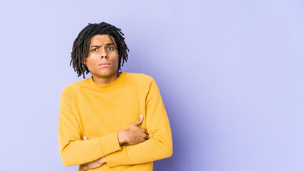 Young black man wearing rasta hairstyle unhappy looking in camera with sarcastic expression.