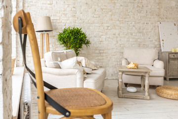 Large spacious room with a trendy loft design of sitting area. huge windows and stylish wicker light furniture inside. an abundance of ethnic decor