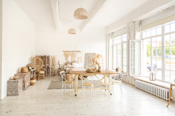 Large spacious room with a trendy loft design of sitting area. huge windows and stylish wicker light furniture inside. an abundance of ethnic decor