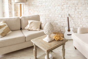 Large spacious room with a trendy loft design of sitting area. huge windows and stylish wicker light furniture inside. an abundance of ethnic decor