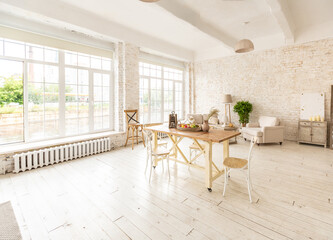 Large spacious room with a trendy loft design of sitting area. huge windows and stylish wicker light furniture inside. an abundance of ethnic decor