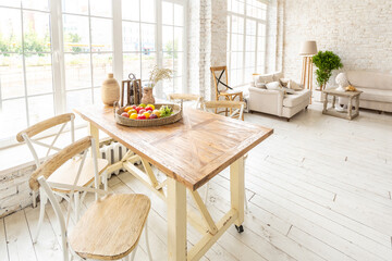 Large spacious room with a trendy loft design of sitting area. huge windows and stylish wicker light furniture inside. an abundance of ethnic decor