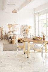 Large spacious room with a trendy loft design of sitting area. huge windows and stylish wicker light furniture inside. an abundance of ethnic decor