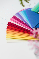 many colored envelopes are spread out on the table in the form of a fan
