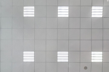cassette suspended ceiling with square halogen spots lamps and drywall construction in empty room...