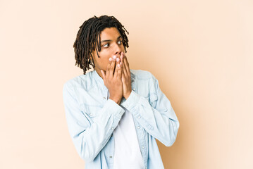 Young african american rasta man thoughtful looking to a copy space covering mouth with hand.