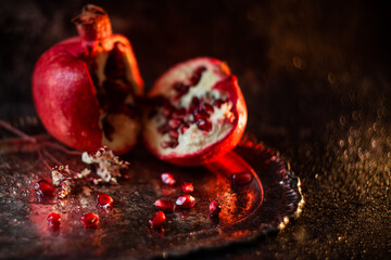 red pomegranate seeds with water drops on a beautiful vintage tray