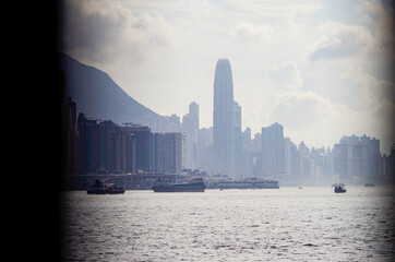 Motor yachts and sailing boats in marina in Victoria Harbor Hong Kong, China with city skyline in...