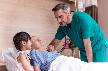 Obraz premium Male doctor check sickness of senior patient on patient bed, beside Lovely girl visit and encourage grandmother in hospital, healthcare and medical concept.