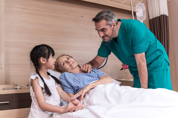 Male doctor check sickness of senior patient on patient bed, beside Lovely girl visit and encourage grandmother in hospital, healthcare and medical concept.