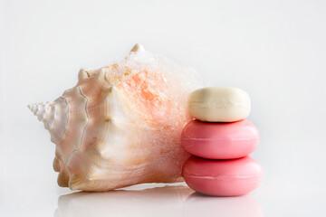Obraz na płótnie Canvas Toilet soap and a pink sea shell on a white background.