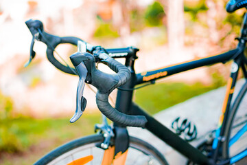 Close-up of modern speed shifter installed on a drop-bar of road bike. Handlebar. Brakes of bicycle. Sport. Handle. Switcher. Set. Transport. Lather bar tape. Blurred background