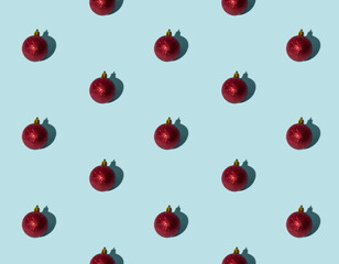 Blue Xmas background. Red bauble seamless pattern. Winter holidays decor. Round shiny glitter ball minimalist composition isolated on light.