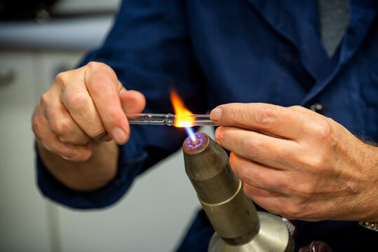 Glass blower forming a chemistry glass, closeup view, glass blower using a glassblowing torch