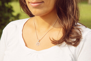 Female neckline wearing tiny silver chain with silver pendant in the shape of tree in mandala - 384192701