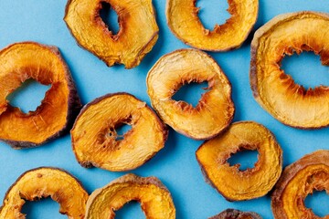 slices of dried persimmon on a blue background. dried fruits. eco.