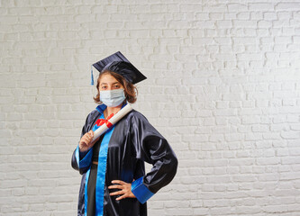 Graduated pandemic and mask girl in front of the wall and certificate.