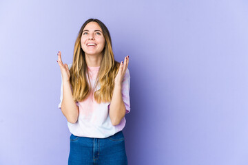 Young caucasian woman isolated on purple background laughs out loudly keeping hand on chest.