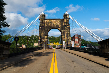 This shows the approach roadway and masonry tower of the historic Wheeling Suspension Bridge that carries the National Road over the Ohio River in Wheeling, West Virginia.