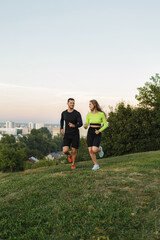 Naklejka premium Couple running outdoors, at sunset, staying active and fit