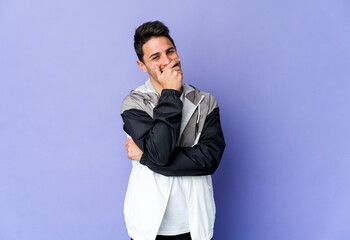 Young caucasian man isolated on purple background laughing happy, carefree, natural emotion.