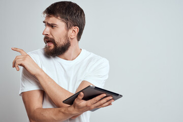 man with tablet shows thumb to the side on gray background cropped view Copy Space