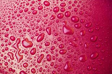 Drops of water on a red glass texture background
