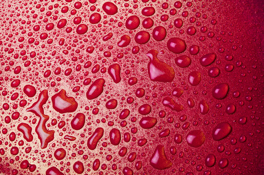 Drops of water on a red glass texture background