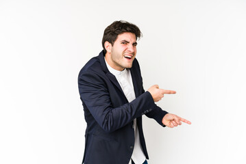 Young business man isolated on white background pointing with forefingers to a copy space, expressing excitement and desire.