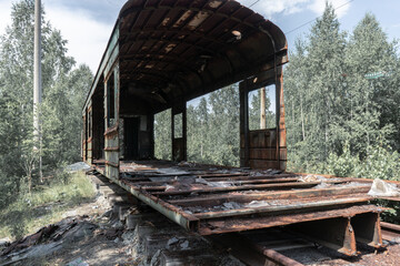 abandoned and destroyed railway carriage in the forest