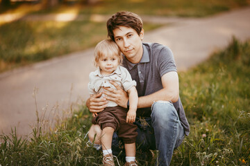 Fototapeta premium A happy man holds his little child in his arms