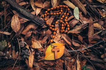 little rosary on autumn texture background. autumn cover of golden leaves. the beauty of the earth in autumn. autumn mood and golden autumn time