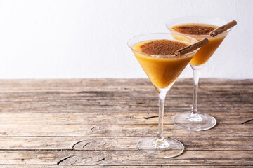 Pumpkin cocktail in glass on wooden table.Copy space