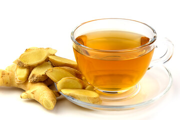 Hot ginger water in a clear glass and fresh ginger on the floor.