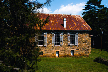 This is an exterior view of derelict wood shutters and windows against sandstone at the abandoned...
