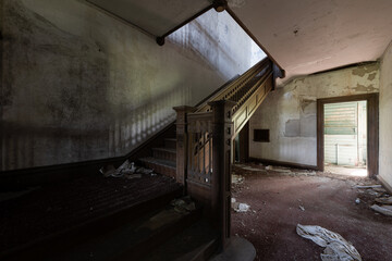 This is an interior view of the first-floor foyer with a stunning wood-paneled staircase at the long-abandoned and historic Dunnington Mansion in Farmville, Virginia. © Sherman Cahal