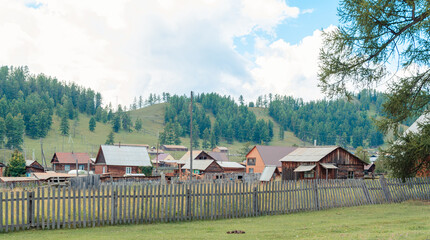 landscape russian village in mountain  rocks summer. Mountain nature, clean air.  Picturesque authentic village  surrounded by mountains. Small houses and gardens in a valley  background from nature