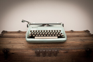 Vintage Typewriter Sitting on Old Wooden Trunk