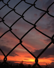 metal mesh with sunset background with clouds