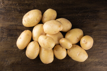 Pile of potatoes lying on rustic background. Top view.