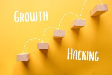 Modern word - growth hacking. New Buzzword, Top view of woodblock with a yellow background. Close up