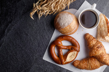 Homemade breads or bun, croissant and bakery ingredients on black slate background, breakfast food concept top view and copy space.top view
