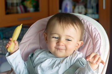 Precioso bebé con gesto de risa comiendo gusanitos