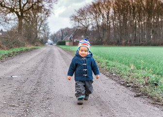 Fototapeta premium Happy toddler walking on footpath