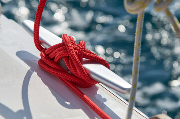 Mit roter Leine belegte Festmacher Klampe an einer Segelyacht