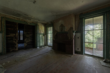 Obraz premium This is an interior view of tall and wide glass windows in the formal dining room at the long-abandoned and historic Dunnington Mansion in Farmville, Virginia.