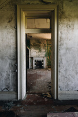 This is an interior view of a bedroom as viewed through a door with a missing transom at the long-abandoned and historic Dunnington Mansion in Farmville, Virginia.