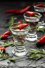 Cold  pepper vodka in shot glasses on  dark  background