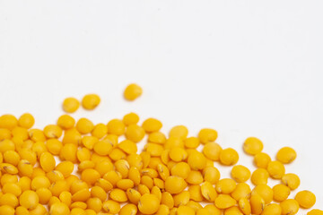 Yellow  lentils scattered on a white background