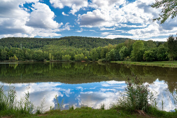 Fototapeta na wymiar Lake with Forest and Cloudy Sky 